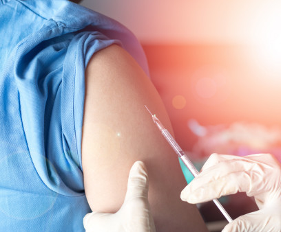 Vaccination healthcare concept. Hands of doctor or nurse in medical gloves injecting a shot of vaccine to a man patient.