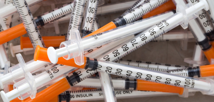 Close up of used syringes in the trash