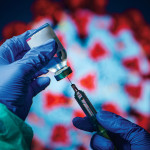 gloved hand needle vial vaccine coronavirus