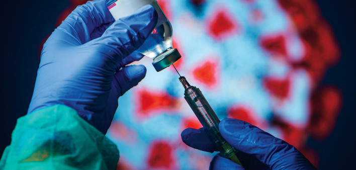 gloved hand needle vial vaccine coronavirus