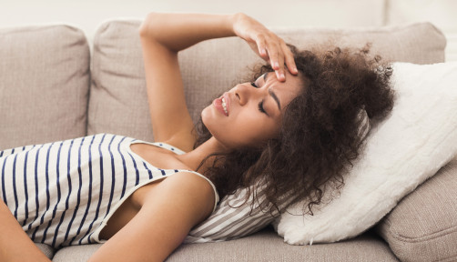 woman girl stomach cramps headache couch