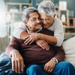 Cropped shot of a cheerful elderly woman hugging her husband who's in a wheelchair at home during the day