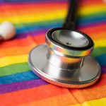 Black stethoscope on rainbow flag background,