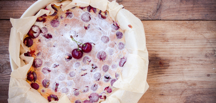 Clafoutis cherry pie on a rustic wooden background