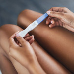 womans hands holding pregnancy test