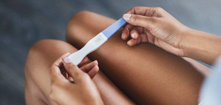 womans hands holding pregnancy test