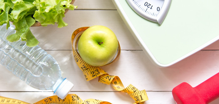 Green apple and Weight scale,measure tape with fresh vegetable, clean water and sport equipment for women diet slimming