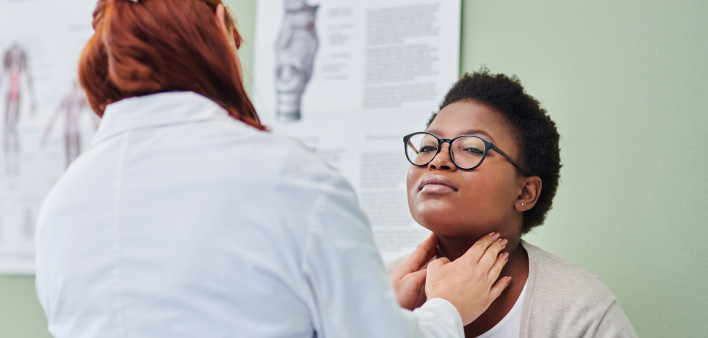 black woman getting thyroid exam