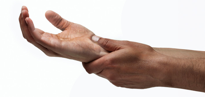 mans hands hold wrist pain