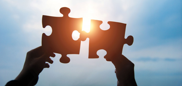 puzzle pieces held up in the sky