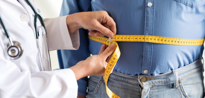 doctor measuring mans stomach