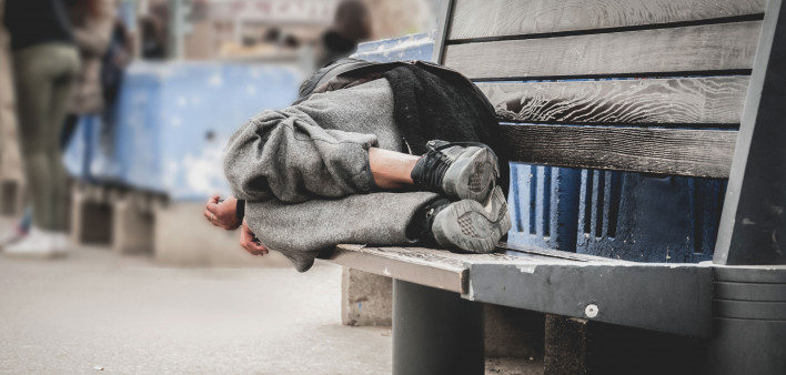 homless person sleeping on a bench