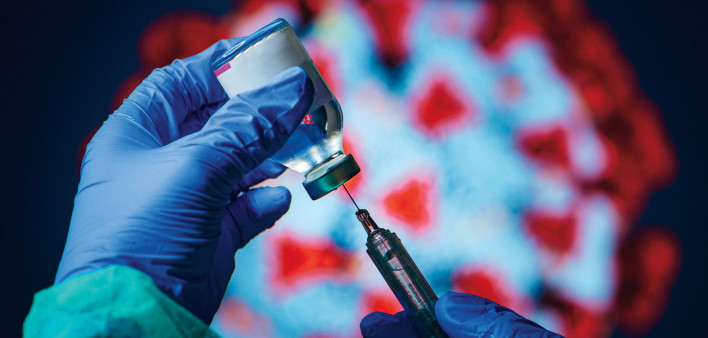 gloved hand needle vial vaccine coronavirus
