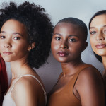 Black women tudio shot of a group of beautiful young women posing together against a gray background