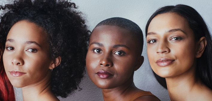 Black women tudio shot of a group of beautiful young women posing together against a gray background