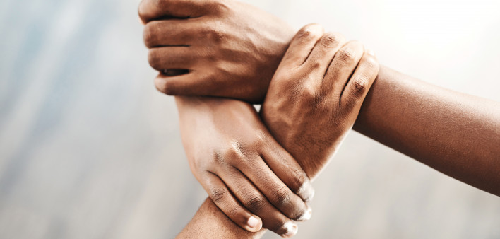 three hands clasping each other triangle