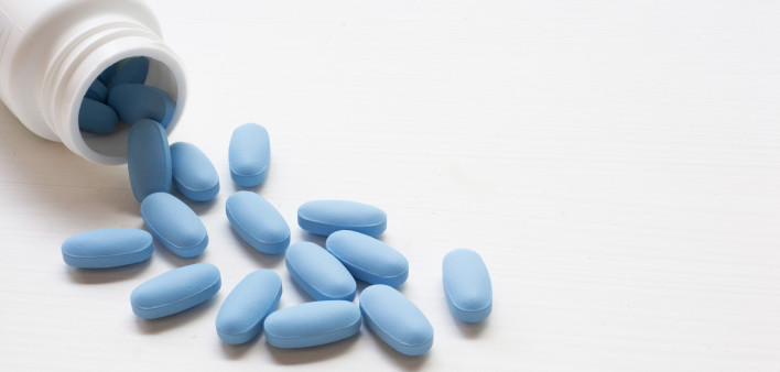 blue pills spilling out of bottle