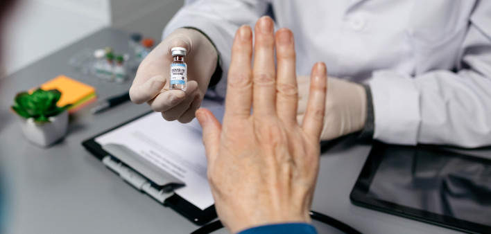 Female patient refusing the coronavirus vaccine offered by her doctor