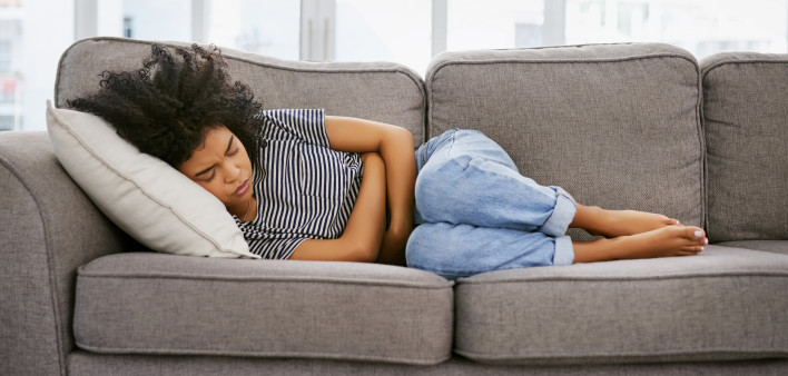 woman girl stomach cramps couch pain