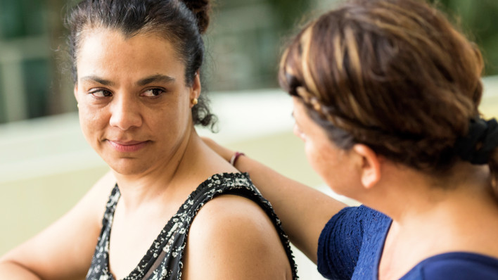 Sad hispanic woman being comforted by a friend