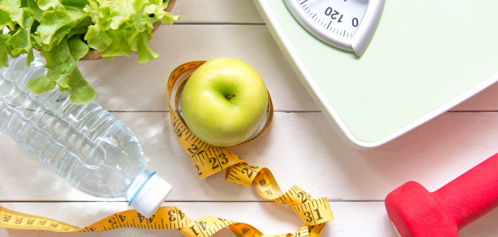 Green apple and Weight scale,measure tape with fresh vegetable, clean water and sport equipment for women diet slimming