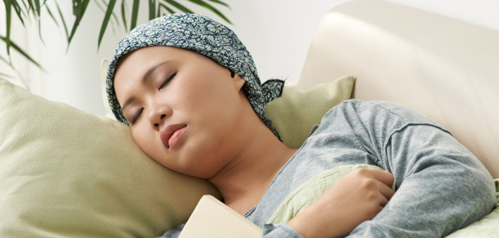 Asian woman with cancer sleeping on couch