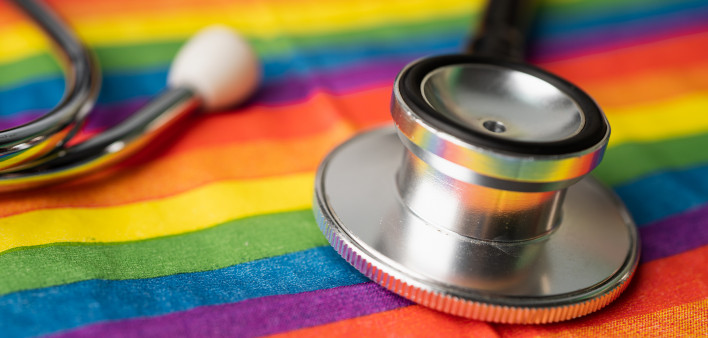 Black stethoscope on rainbow flag background,