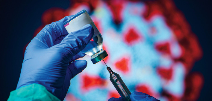 gloved hand needle vial vaccine coronavirus