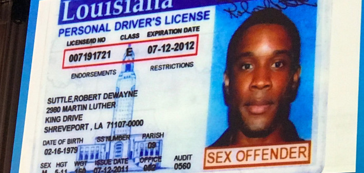 HIV advocate Robert Suttle displays his driver’s license during an AIDS conference presentation
