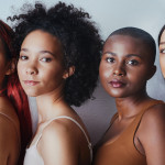 Black women tudio shot of a group of beautiful young women posing together against a gray background