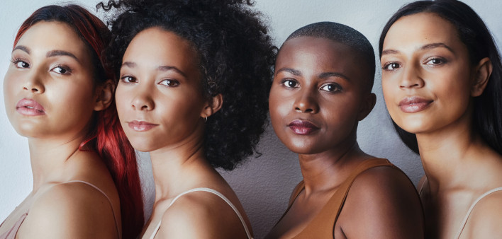Black women tudio shot of a group of beautiful young women posing together against a gray background