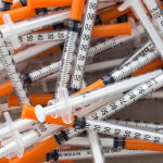 Close up of used syringes in the trash