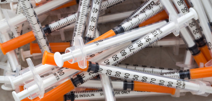 Close up of used syringes in the trash