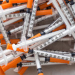 Close up of used syringes in the trash