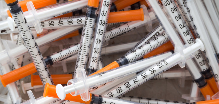 Close up of used syringes in the trash