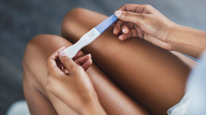 womans hands holding pregnancy test