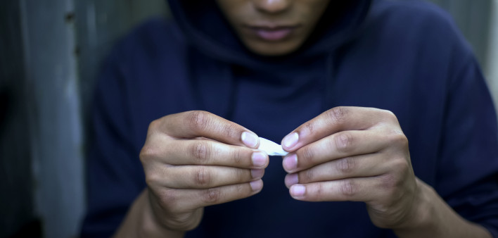 Teenager addict making cigarettes with marijuana, health problems risk, oncology