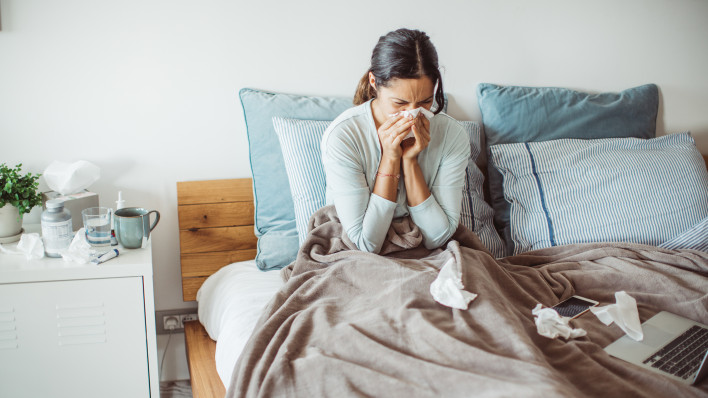 Woman with flu in bed, she use home medicine to handle sickness