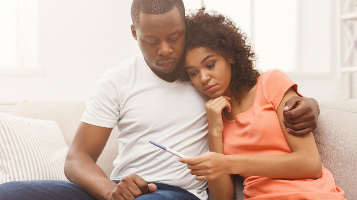 african american couple black looking at pregnancy test