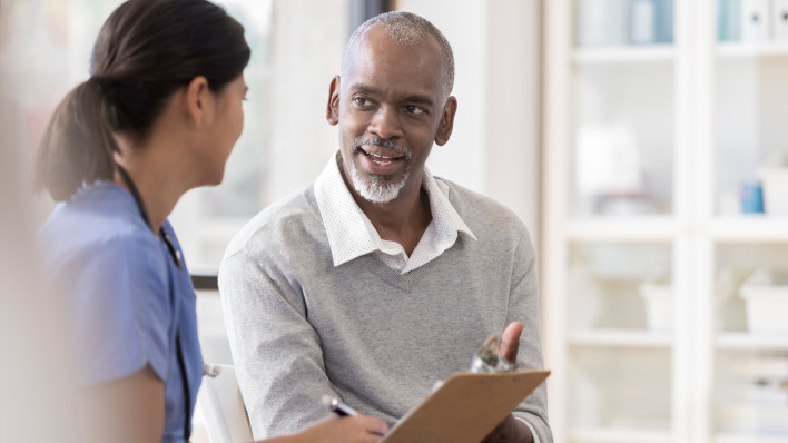 Senior man discusses diagnosis with doctor