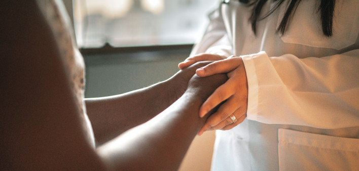 Doctor holding patients hands