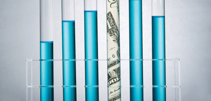 test tubes with blue liquid and money in one tube