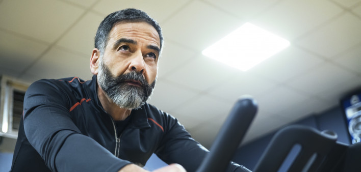 mature man exercise bike gym spin