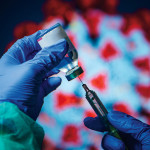 gloved hand needle vial vaccine coronavirus