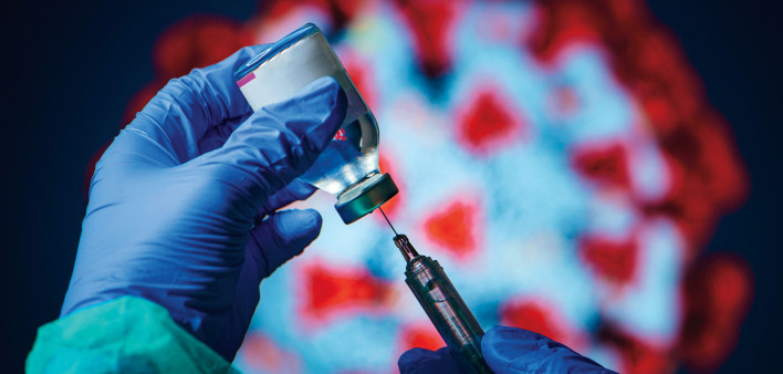 gloved hand needle vial vaccine coronavirus