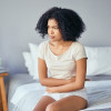 woman girl stomach cramps bed