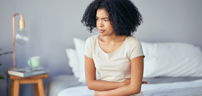 woman girl stomach cramps bed