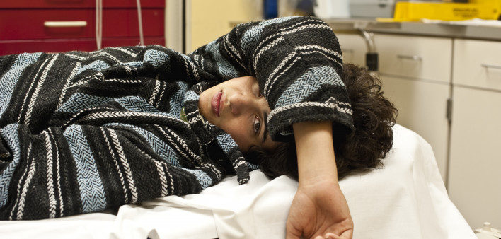 Teenager in a hospital emergency room looking at the camera, could be for overdose, alcohol, depression, accident or any other medical condition