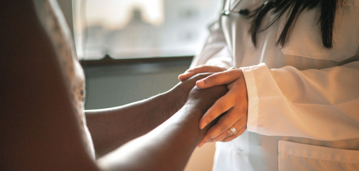 Doctor holding patients hands