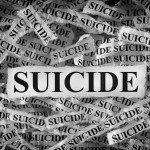 Torn pieces of paper with the words Suicide